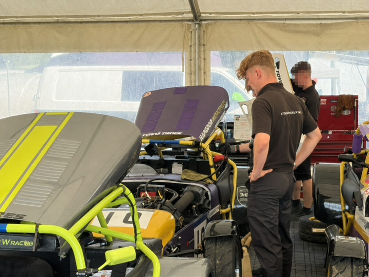 Joshua Worrall working on a Caterham race car with the bonnet raised